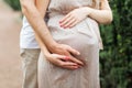 Man Hands Hug Pregnant Woman by Belly Closeup Photography. Staying Beautiful Pregnancy Girl Dressed in Dress. Future