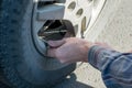 People hands insert the hose of the car pump to pump air into the wheel of the car Royalty Free Stock Photo