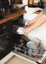 Man hands loading the dishwasher close up, man chores and hosework concept Royalty Free Stock Photo