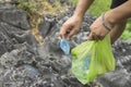 Man hands picking up litters on rock at tourism place Royalty Free Stock Photo