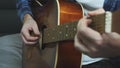 Man hands playing on acoustic guitar. Fingers strumming on acoustic guitar strings. Close up