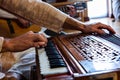 Man hands playing harmonium in room