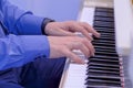 Man hands playing on white grand piano on concert - side view Royalty Free Stock Photo