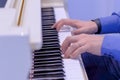 Man hands playing on white grand piano on concert - side view Royalty Free Stock Photo