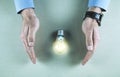 Man hands protect light bulb. Saving electric energy Royalty Free Stock Photo