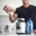 Man, hands and protein shake for nutrition, muscle gain or body mass product and supplement on kitchen table. Hand of