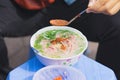 Man hands putting chili soup into Pho, the Vietnamese noodle soup. Pho is the most famous food in Vietnam Royalty Free Stock Photo