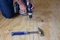 Man hands screwing plywood down on the floor. Royalty Free Stock Photo