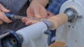 Man hands shaping piece of wood on lathe at workshop - close up Royalty Free Stock Photo