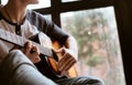 Man hands sitting on the big window windowsill and playing on guitar - fingers close up image Royalty Free Stock Photo