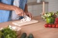 Man hands slicing vegetable for salad at the kitchen, croped shot Royalty Free Stock Photo