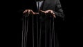 Man hands with strings on fingers on black background. Violence, harassment, bullying concept. Master in business suit