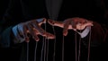 Man hands with strings on fingers. Hands close up pulling strings. Man in business suit manipulates puppet. Puppeteer