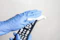 Man hands with surgical gloves cleaning the tv remote control with disinfectant wet wipes . Prevention of bacteria and