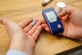 Man hands on the table holding glucometer and stripes for checking blood sugar level, diabetes concept. Royalty Free Stock Photo