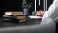 Man hands taking notes in notebook. Businessman sitting at table with books or codes and writing agenda, information for