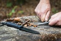 Man hands trying to start a fire with survival tools