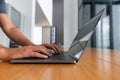 Man hands typing on the laptop keyboard on wooden desk Royalty Free Stock Photo