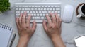 Man typing on wireless keyboard over his workspace. Royalty Free Stock Photo