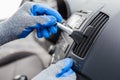 Worker cleaning automobile air conditioner vent grille with brush, closeup. Car wash service Royalty Free Stock Photo