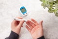 Man hands using lancet on finger to check blood sugar or ketones level by glucose meter. medicine diabetes keto diet health care