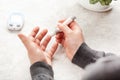 Man hands using lancet on finger to check blood sugar or ketones level by glucose meter. medicine diabetes keto diet health care
