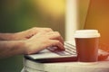 Man hands using laptop and coffee to go outdoor closeup Royalty Free Stock Photo