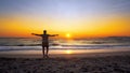 Man with hands wide open in VICTORY pose walks on empty ocean beach into water Royalty Free Stock Photo