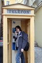 Man with handset in street callbox. Royalty Free Stock Photo