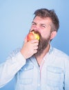 Man handsome hipster with long beard eating apple. I love apples Man diet nutrition eats fruit. Hipster hungry bites