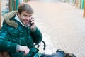 Man handsome hold smartphone. Man unshaven wear warm jacket and hold smartphone snowy urban background. Guy sit bench