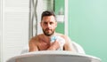 Man handsome muscular guy relaxing in bath. Pampering and beauty routine. Skin care concept. Taking bath with soap suds Royalty Free Stock Photo