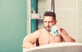 Man handsome muscular guy relaxing in bath. Spa wellness concept. Taking bath with soap suds. Treating yourself with hot Royalty Free Stock Photo