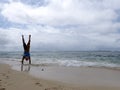 Man Handstand on beach as wave roll into Shore