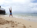 Man Handstand on beach as wave roll into Shore