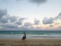 Man Handstanding on beach at Dusk with Dog spotting the pose