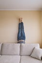 Man handstanding behind the couch in yoga