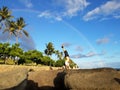 Man Handstanding on coastal rocks with Rainbow overhead