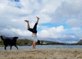 Man Handstands on beach with black dog next to him in Hawaii Kai Royalty Free Stock Photo