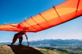 Man with hang-glider starting to fly from the hill top Royalty Free Stock Photo