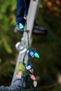 Feet of man on ladder decorating hands hold ladder