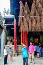 Man hanging foreigner tourist's incense coils at Thien Hau Pagoda, Cho Lon, Saigon, Vietnam Royalty Free Stock Photo