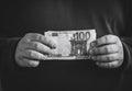 Man hanging money in hands. Man shows one hundred euro banknote. Black and white Royalty Free Stock Photo