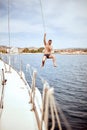 Man hanging out, having fun and enjoying summer days jumping from sailing boat in sea Royalty Free Stock Photo