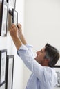 Man Hanging Picture Frames On Wall At Home Royalty Free Stock Photo