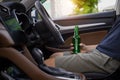 Man hangover in car after party. alcoholic man holding beer bottle in car. a