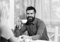 Man and happy face holds cup of hot drink on light cafe background, defocused. Guy drinks coffee or tea at table. Man Royalty Free Stock Photo