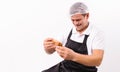 A man with a happy smile and a black apron. Chef with a bowl of honey on a white plate with empty side space.