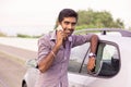Man happy talking on the phone leaning on the door of his car Royalty Free Stock Photo