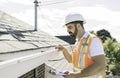 man in a hard hat, holding a clipboard, standing on the steps of an old rundown house. Royalty Free Stock Photo